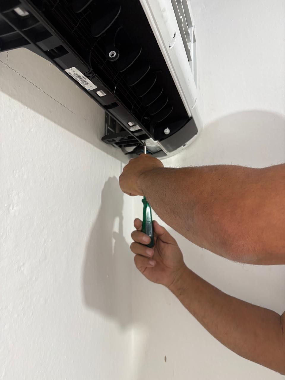 Técnico da JM executando manutenção preventiva em ar condicionado split